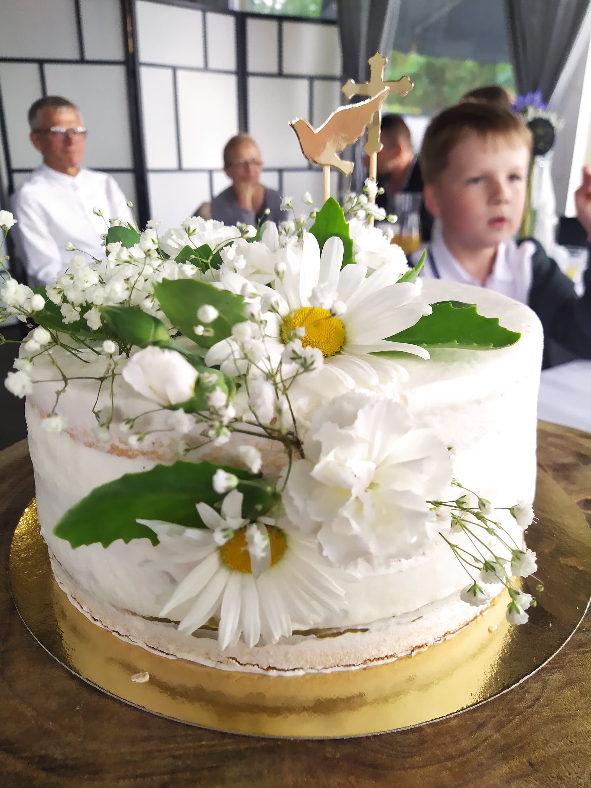 Uroczysty tort komunijny z kwiatami, gołąbkiem i krzyżykiem